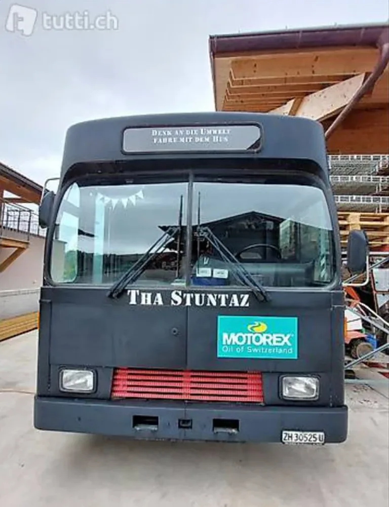 Schwarzer Bus mit Umwelt- und Motorex-Werbung.