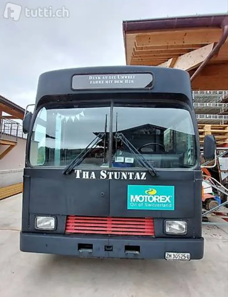 Schwarzer Bus mit Umwelt- und Motorex-Werbung.
