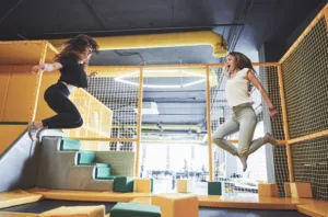 Zwei Frauen springen im Trampolinpark.
