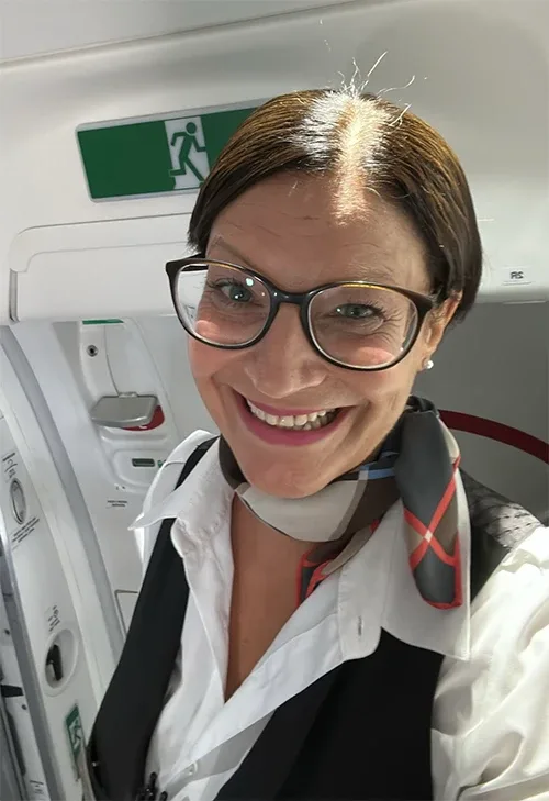 Lächelnde Flugbegleiterin im Flugzeug.